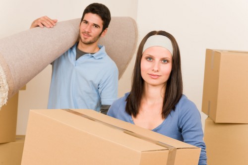 Professional movers carrying furniture through a Clapton property