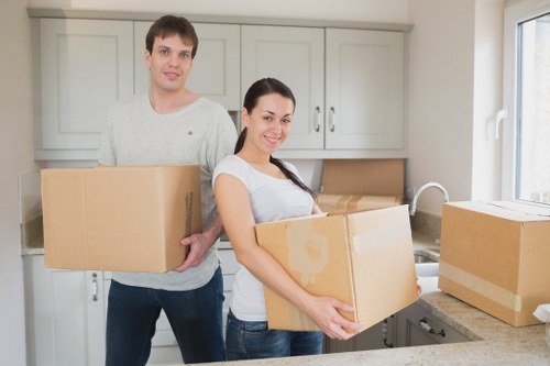 Local movers carrying furniture near residential streets in Clapton